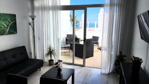 阿德耶Ocean View Apartments的客厅配有黑色沙发,享有海景