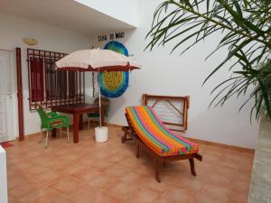 MorroBarracudamaio的庭院配有椅子、雨伞和桌子