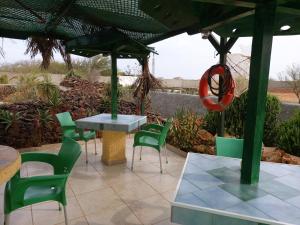 MorroBarracudamaio的庭院配有绿色椅子、桌子和雨伞