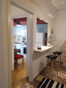 雅典Maria's Cozy apartment in Palaio Faliro的厨房配有白色橱柜、柜台和凳子