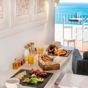 阿尔啼Porta Nova Suites Altea - Adults Only的一张桌子,上面有食物,享有海景