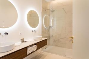 塞特港Les Clés Secrètes的浴室设有水槽和带镜子的淋浴