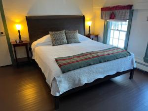 ShorehamShoreham Inn Bed & Breakfast的卧室内的一张大床,配有两盏灯