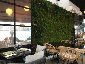马德里Hotel Suites Feria de Madrid的餐厅设有绿色墙壁,配有桌椅