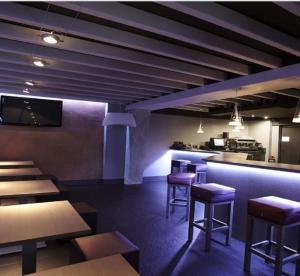 普伦西亚KAIAN MAITEA的一间设有紫色凳子的餐厅和一间酒吧