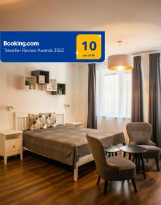 布达佩斯Baleo50 Apartment的一间卧室配有一张床、两把椅子和一张桌子