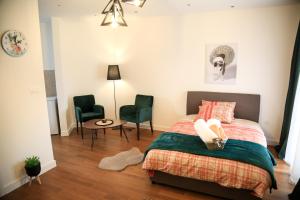 波德戈里察Aria Apartmani的一间卧室配有一张床、两把椅子和一张桌子