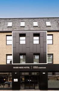 因弗内斯River Ness Hotel, a member of Radisson Individuals的前面有河水的旅馆