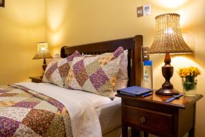 克萨尔特南戈Hacienda Grande Hotel的一间卧室配有一张床和一张带台灯的桌子
