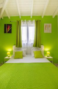 勒穆莱Les Villas de Boisvin的绿色卧室设有一张带绿色墙壁的大床