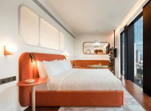 曼谷曼谷仕丹德大京都大厦酒店的一间卧室配有一张大床和一张桌子