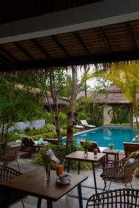 西塔努Amaya Boutique Resort的一个带桌椅的庭院和一个游泳池
