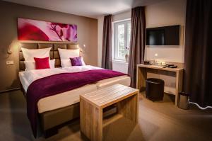 霍尔茨明登施瓦格韦斯特酒店的酒店客房设有一张大床和一张书桌。