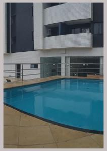 圣路易斯Flat Biarritz - Ao lado da Litoranea - Ferreira Hospedagens的大楼前的大型蓝色游泳池