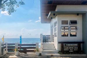 CandonE. Moreno Recreation Beach Resort Ilocos Sur的一座白色的房子,背景是大海