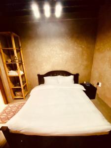 尼兹瓦Jawharat Alaqar Inn نزل جوهرة العقر的卧室配有一张白色大床