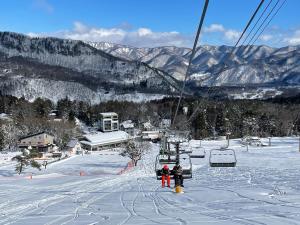 白马村ROKA by Hakuba Hotel Group的雪地滑雪缆车上的两个人