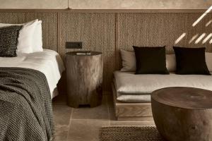 蒂锡利维齐勒全套房酒店 的一间卧室配有一张床、一张沙发和一张桌子