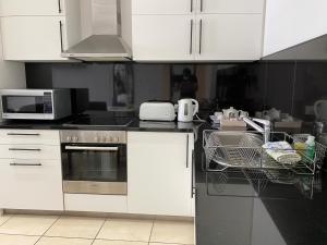 开普敦地标豪华公寓的厨房配有白色橱柜和洗碗机。