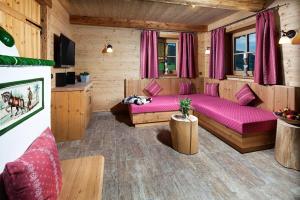 拉姆绍艾特勒恩度假屋的小屋内带紫色床的客厅