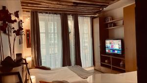 巴黎Gorgeous Paris St Germain des Près的卧室配有一张床,窗户前配有电视