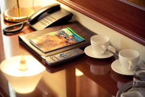 圣彼得堡克里斯托弗酒店的一张桌子,上面有两个杯子,还有一部电话和一本书