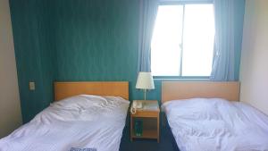 阿南Bayside Hotel Ryugu / Vacation STAY 63714的卧室内两张并排的床