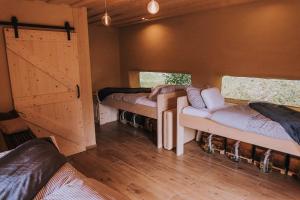 格罗苏普列Sleeping with bees - Tourist farm Muha的带3张床和推拉门的客房