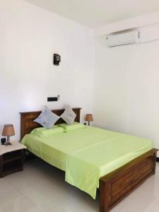 米瑞莎Mirissa Paddy House的一间卧室配有一张带绿色棉被的床