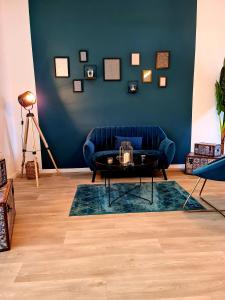 图尔昆NG SuiteHome - Lille I Tourcoing Winoc - Appartement T2 - Netflix - Wifi - Cuisine - Parking gratuit的客厅配有蓝色的沙发和桌子