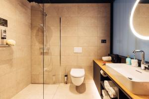 比绍夫斯霍芬harry's home Bischofshofen hotel & apartments的带淋浴、卫生间和盥洗盆的浴室