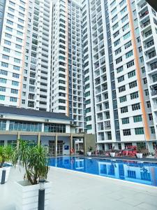 怡保Adelea Homestay MERU的大型公寓大楼,高楼前设有游泳池