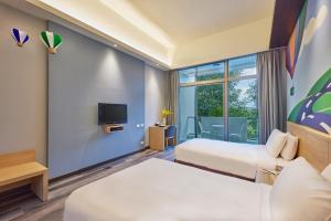 台东娜路湾会馆的一间酒店客房,设有两张床和电视