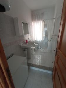 西尼斯科拉Carpe Diem的白色的浴室设有水槽和卫生间。