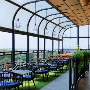 JomblangKala Hotel Semarang的餐厅设有桌椅和窗户。
