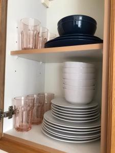 BelvedereLuxurious & Spacious 5 Bedroom Property的装有盘子、碗和玻璃杯的橱柜
