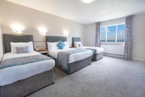 托基Livermead Cliff Hotel的酒店客房设有两张床和窗户。