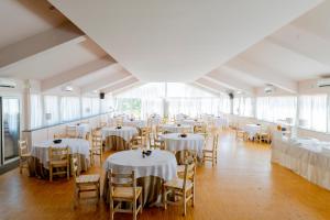 卡塔尼亚乐度纳西西里酒店的一间设有桌椅和白色桌布的房间