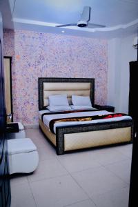 拉合尔Hotel Tulip Inn的一间卧室配有一张带花卉墙壁的床