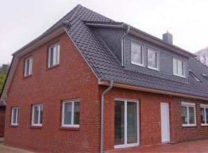 索尔陶Ferienwohnungen Im Dorfe Neu ab April 2022的黑色屋顶红砖房子