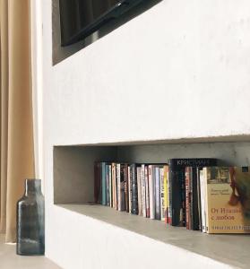 阿拉帕亚Cabo Villas的书架上书本和一瓶