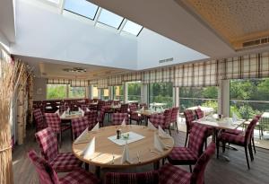 ViechtHotel Traunfall的用餐室设有桌椅和窗户。