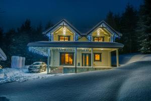 布克维WhiteWood Cottages的雪中停放汽车的房子