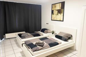 科隆Ferienwohnung Köln Junkersdorf的配有黑色窗帘的客房内的两张床
