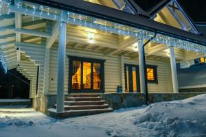 布克维WhiteWood Cottages的雪中遮盖着圣诞灯的房子