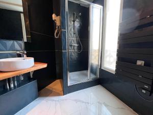 巴黎特尔的酒店的一间带玻璃淋浴和水槽的浴室