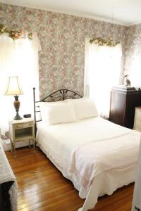 布鲁克林布鲁克林柯立芝角落住宿加早餐宾馆的一间卧室配有一张床和一张带花卉壁纸的墙壁