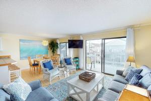 大洋城Sunrise Sea 210的客厅配有蓝色的沙发和桌子