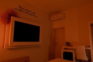 阿尔盖罗Sunshine Charming Houses的客厅的墙上配有电视