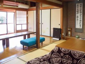 新宫市Shingu Guest House 奏的客厅配有桌子和蓝椅